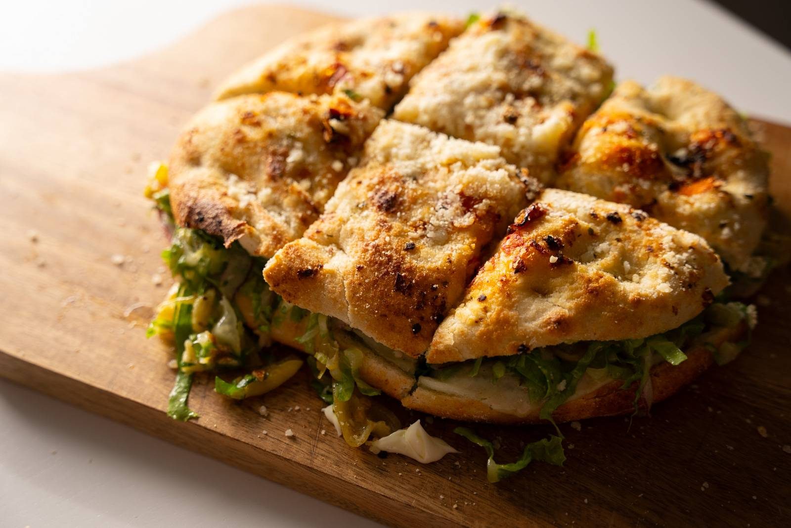 Focaccia sandwich sliced on a cutting board.